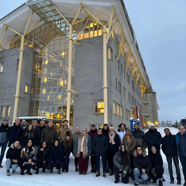 Ignition project partners outside a building in a snowy landscape